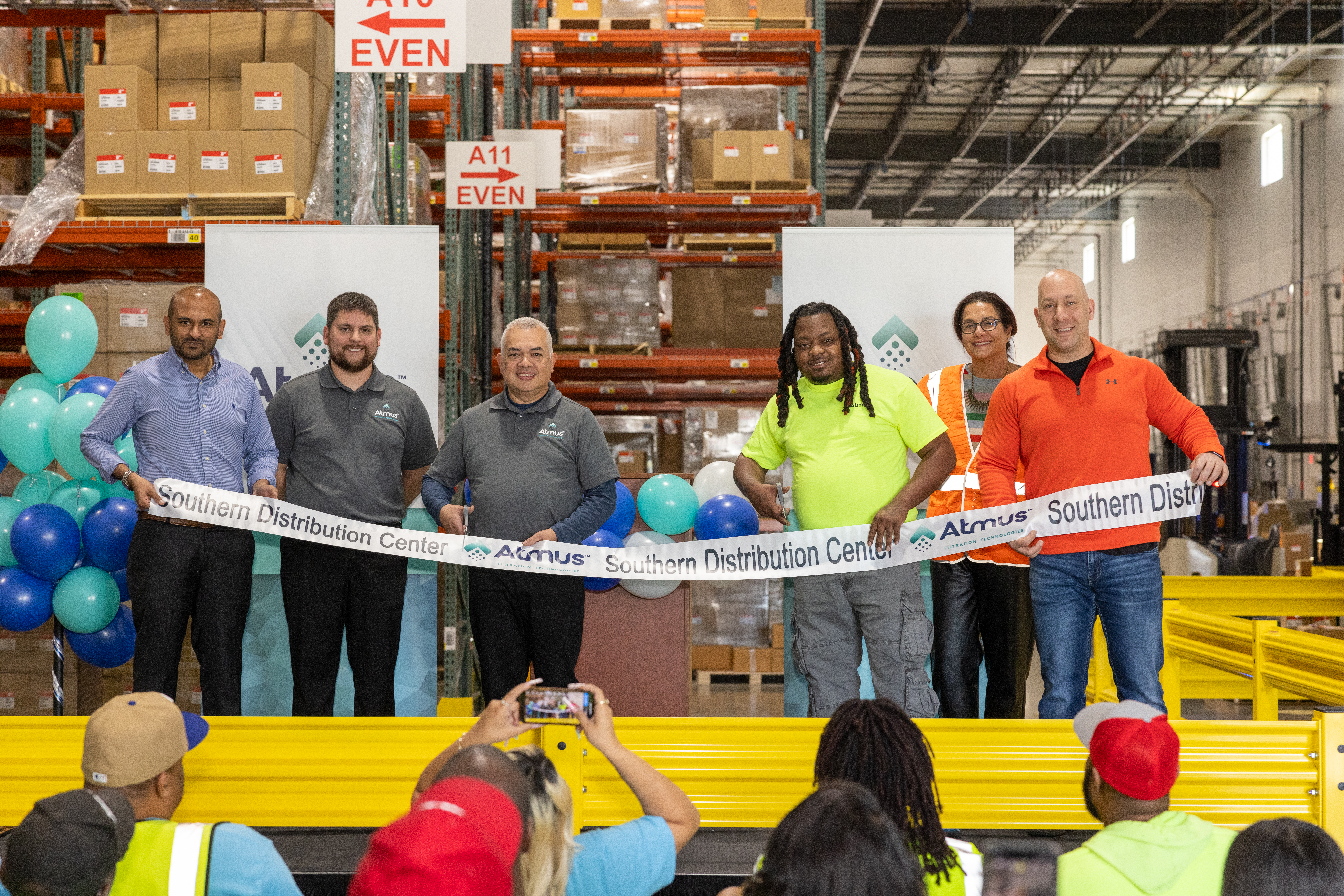 Arif Mujawar (Planning & Logistics Director), Andrew McLellan (SDC Site Leader), Mario Gomez (Warehouse Associate), LaQuintus Nash (Warehouse Associate), Hedy Groff (Executive Director, NA Aftermarket & Sales Operations) and Benjamin Smith (Regional Logistics Director) cut the ribbon to inaugurate the SDC